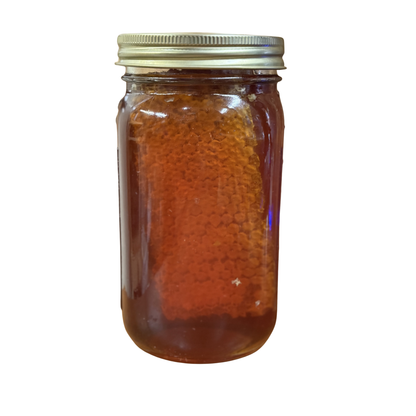 Side view of Chunk Honey glass jar with Chilton Bee Company label, raw honeycomb visible inside, white background